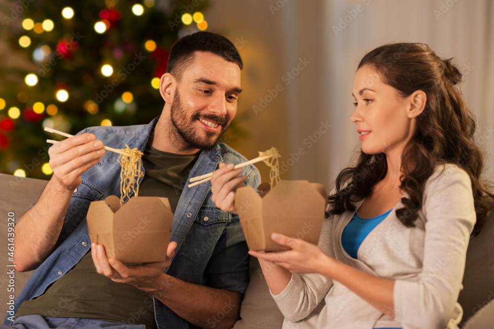 Sticker winter holidays, fast food and people concept - happy couple eating takeaway noodles with chopstick 