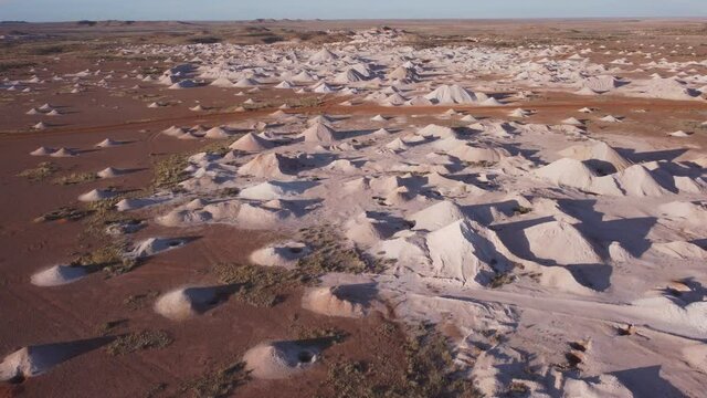 an ascending aerial shot of opal mine mullock heaps at coober pedyy in outback south australia