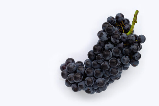 Fresh black grapes on white background.
