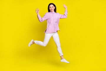 Fototapeta na wymiar Full body photo of funky brown hairdo young lady run arms up wear pink shirt pants isolated on yellow color background