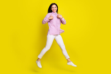 Fototapeta na wymiar Full length body size view of attractive cheery girl jumping showing two thumbup ad isolated over bright yellow color background