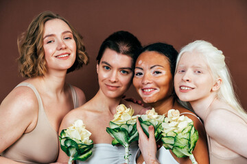 Group of multiethnic women with different kind of skin posing together in studio. Concept about...