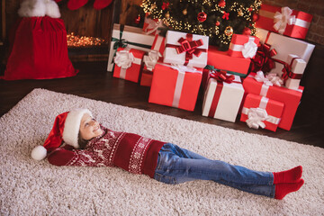 Photo of sweet shiny school girl wear print pullover headwear smiling lying floor arms behind head indoors house home room