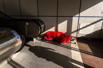 Woman sleeping in subway entrance