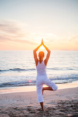 Beautiful woman doing yoga by the sea - 461446956