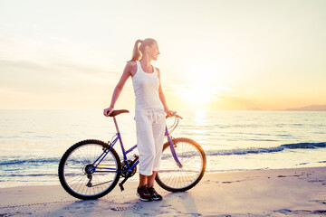 Beautiful woman rides a bicycle by the sea