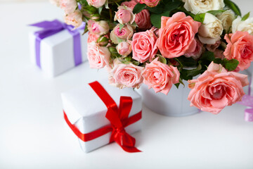 Bouquet of pink roses and boxes with gifts