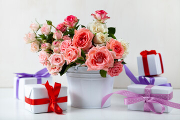 Bouquet of pink roses and boxes with gifts