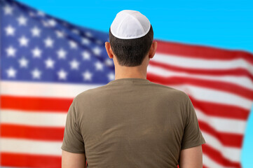 Back view of jewish citizen wearing yarmulke in front of american flag for multi-ethnicity nature of USA - obrazy, fototapety, plakaty