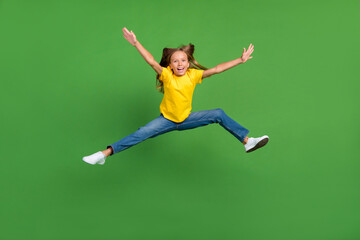 Fototapeta na wymiar Full length body size view of attractive free cheery girl jumping having fun isolated over bright green color background