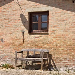 An old wooden bench under a wooden window of a stone farmhouse in the italian countryside (Tuscany, Italy, Europe) - 461450958
