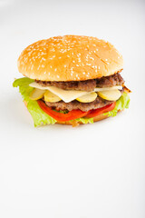 hamburger with two cutlets and cucumbers with tomatoes