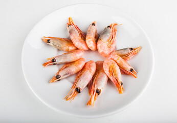 fresh shrimp for frying on a white plate