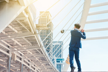 Young successful businessman playing golf with cityscape background. Business target concept.