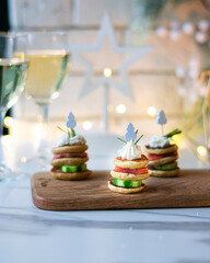 Christmas tree canape with cucumber slice, salmon pate and red caviar for festive xmas snack. Vertical