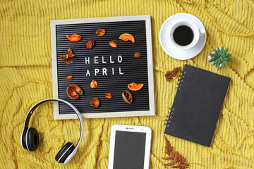 Hello April written on the letter board with multimedia accessories and coffee flat lay concept