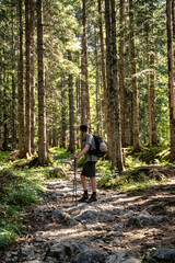 Junger Mann macht Pause vom wandern durch den Wald in der Natur in Österreich