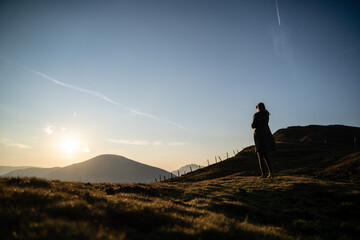 Junge Frau fotografiert nach Wanderung bei Sonnenaufgang am Berg in Salzburg Österreich