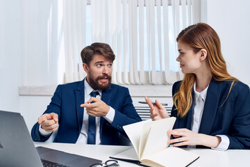 colleagues sitting at a desk in front of a laptop officials