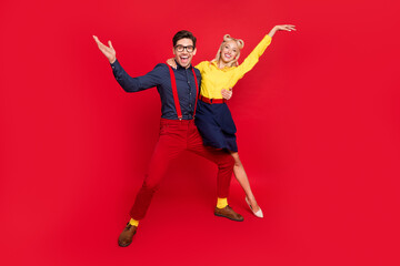 Photo of funny charming young lady guy dressed pinup outfits dancing boogie woogie rising hands arms isolated red color background