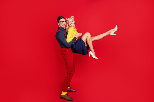 Photo of sweet funky young guy lady wear pin up clothes smiling dancing swing smiling isolated red color background