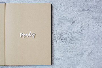 Monday flat lay minimalist concept with book on grey cement background