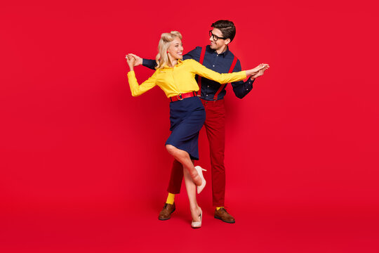 Photo of charming adorable young lady guy dressed pinup outfits holding hands arms dancing boogie woogie isolated red color background