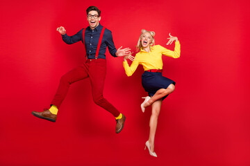 Fototapeta na wymiar Full length body size view of attractive cheerful couple jumping fooling dancing jive lindy isolated over bright red color background