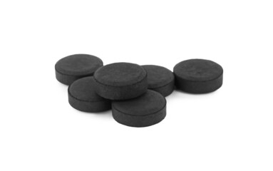 Activated charcoal pills on white background. Potent sorbent