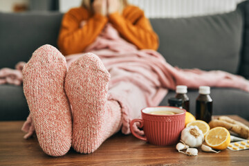 Woman with warm socks having a heavy flu - obrazy, fototapety, plakaty