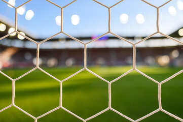 Fototapeta premium The net in the soccer goal and stadium in the background.