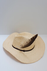 Beige female hat on the white background. Concepts of journey, holidays, rest, weekend escape