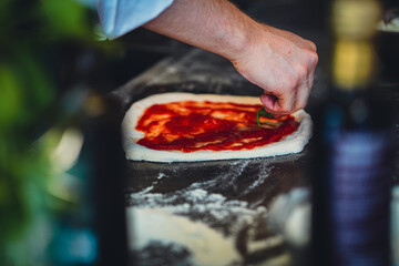 pizza chef preparing raw dough pizza olive oil basil mozarella fresh italian style napoletana napoli pizza about to be in oven