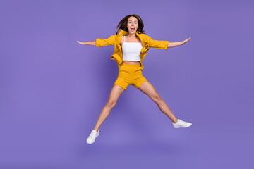 Fototapeta na wymiar Full body photo of cool millennial lady jump wear yellow suit sneakers isolated on violet background