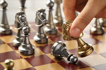 Woman moving chess piece on board, closeup