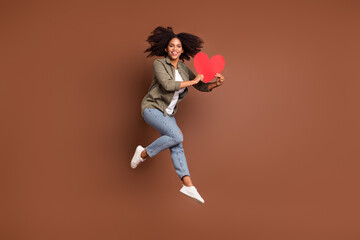 Fototapeta na wymiar Full body portrait of charming overjoyed girlfriend hold large red paper card isolated on brown color background