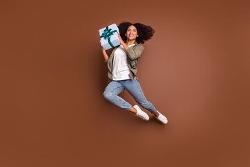 Fototapeta na wymiar Full size portrait of satisfied person hands hold desirable giftbox have good mood isolated on brown color background