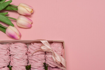 box with marshmallows. pink background. pink marshmallows. flowers for girl