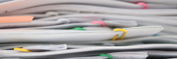 Stack of reporting paper documents on desktop