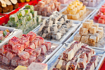 Turkish national sweets are sold at the fair. Multi-colored Asian desserts stacked on the table. Rahat lokum in bulk is sold at the festival.