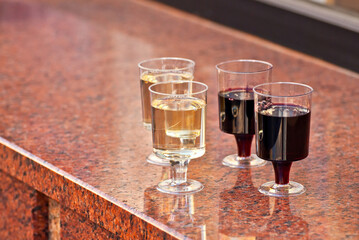 Plastic glasses with wine close up. Different types of wine on a marble table.