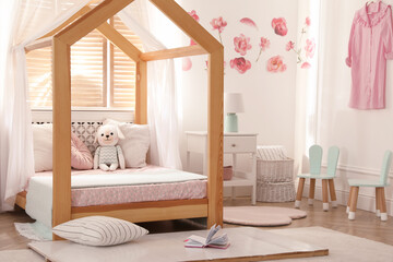 Stylish child room interior with wooden house bed