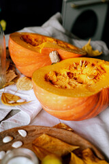 There is a layout of pumpkin and autumn leaves on the kitchen table 