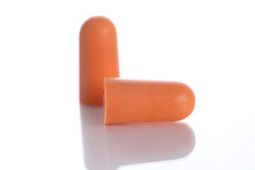 Two orange soft ear plugs on white background