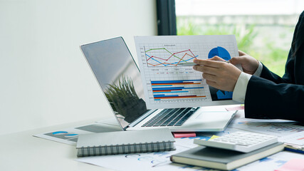 Business finance and accounting concepts using laptops and calculators to analyze, graph, report, budget, and plan for the future in your company's office.