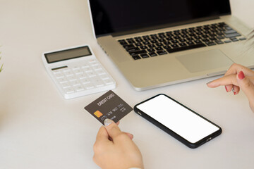 businesswoman holding a credit card while using mobile phone with white screen Businessmen shopping online, e-commerce, internet banking spending money work from home concept