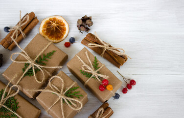 Christmas composition. Christmas gifts, pine cones, fir branches on white wooden background. 