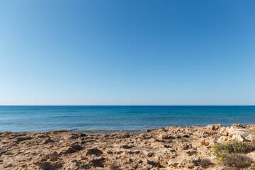 Fototapeta na wymiar Beautiful seascape. Travel concept. Seascape on the background of the wild rocky coast. Wild beach, azure water and rocks. Luxury summer adventure, Mediterranean sea, Cyprus. Postcard view