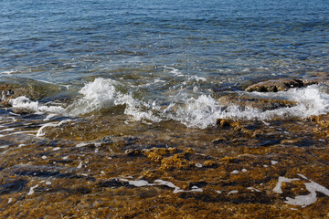 Sea waves on the wild rocky coast. Beautiful seascape. Travel concept. Seascape on the background of the wild rocky coast. Wild beach, azure water and rocks. Mediterranean sea, Cyprus. Postcard view