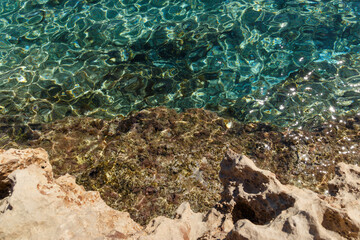 Sea waves on the wild rocky coast. Beautiful seascape. Travel concept. Seascape on the background of the wild rocky coast. Wild beach, azure water and rocks. Mediterranean sea, Cyprus. Postcard view